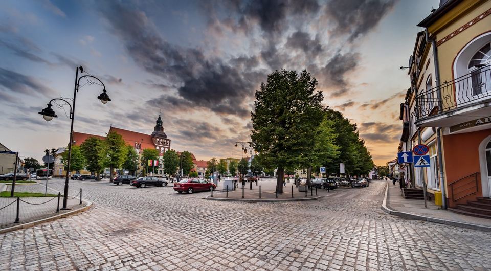 Brukowana ulica w centrum Gryfic, w tle gotycki kościół