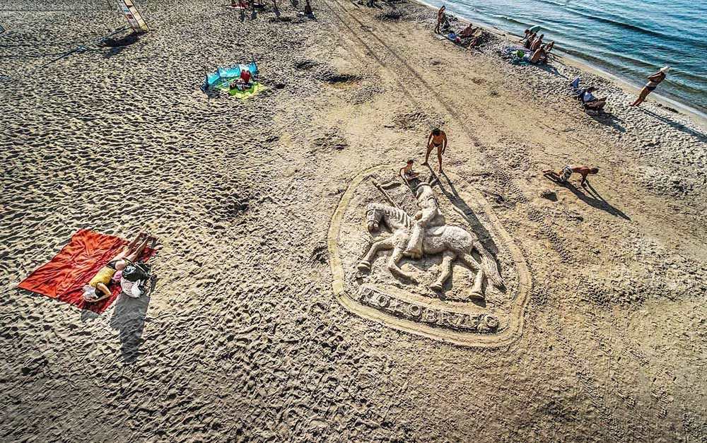 Rzeźba herbu Kołobrzegu z piasku na plaży